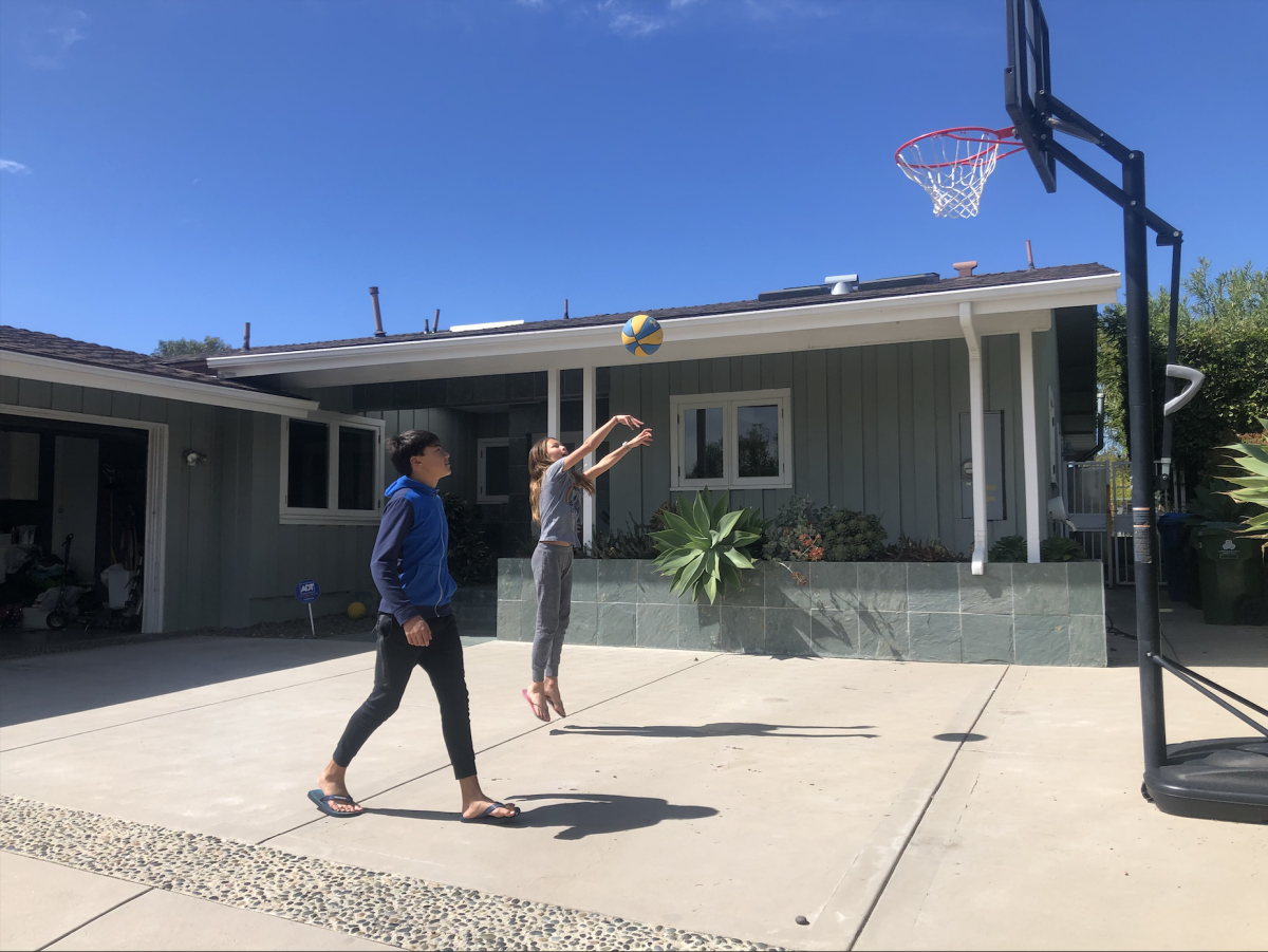 Cara and her brother play basketball at their home.